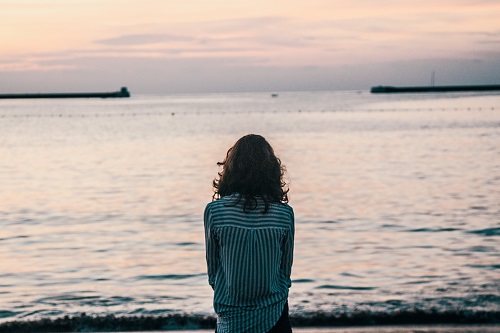 一個女人傍晚在海邊的背影