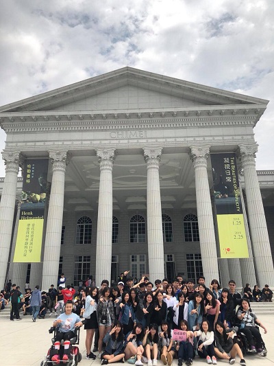 全班大合照，背後是一間博物館，博物館上方有藍天白雲。