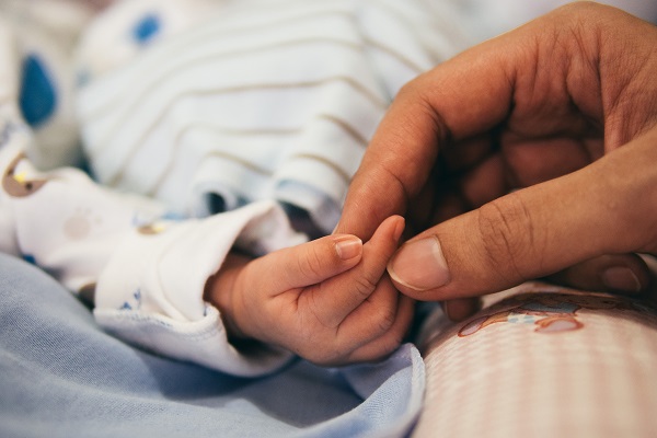 一隻母親的手拉著初生嬰兒的手