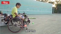 一至黃衣服的運動員坐在輪椅上，手持網球拍打網球