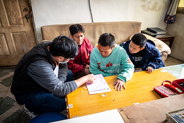 劉書宏與阿宏等母子三人一起在客廳桌上一起對著桌上的紙張討論春節注意事項。