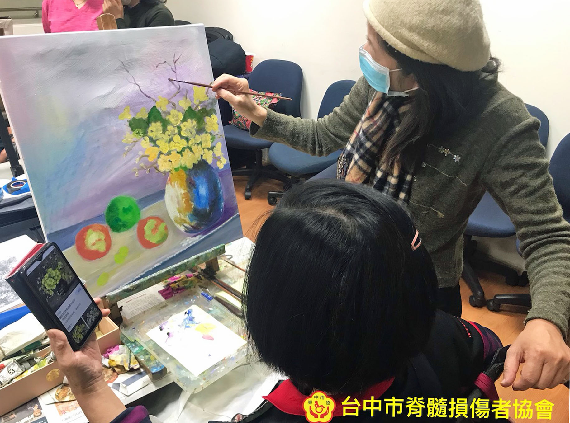 作者參加協會活動的繪劃課程，老師正在指導她的作品。